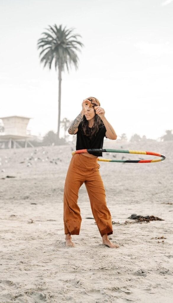 Woman hula hooping on the beach